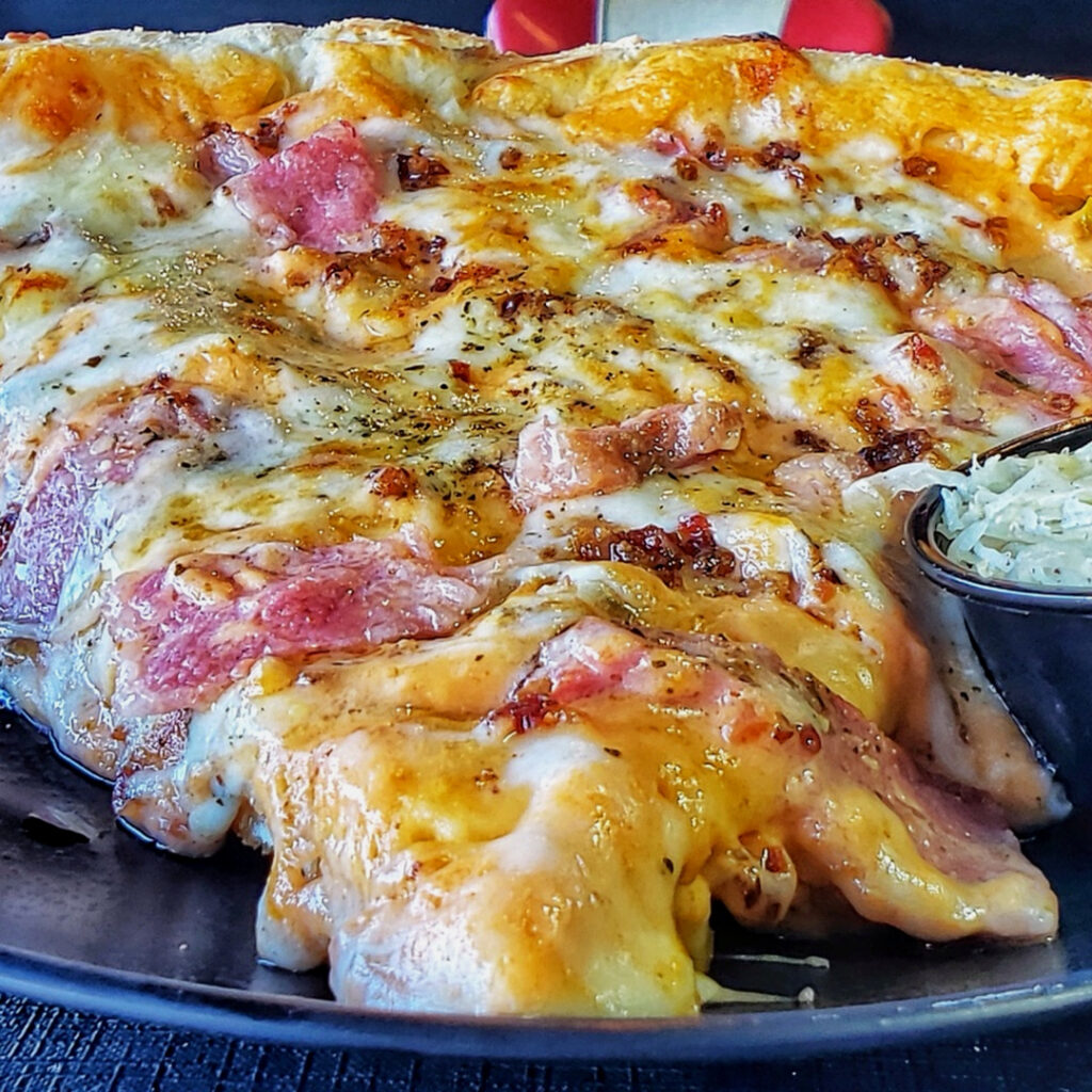 Close-up of Irish Reuben Pizza showing melted cheese and Vienna Beef corned beef