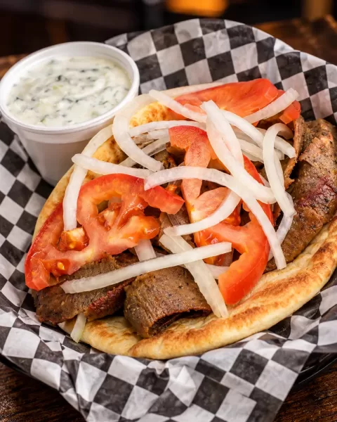Frato’s gyro on pita with tomato and onion, with a cup of house-made tzatziki