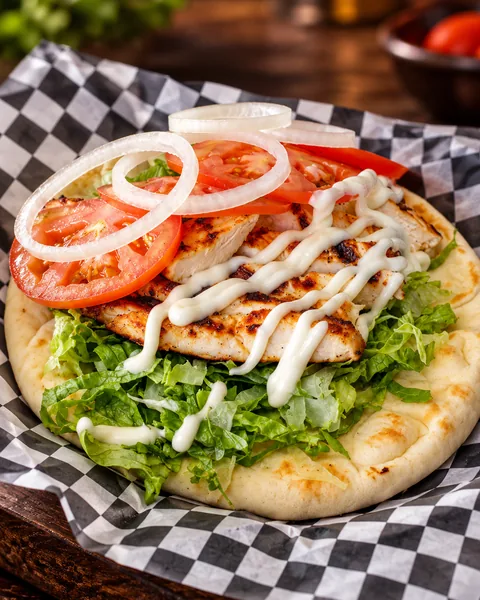 Grilled halal chicken pita with lettuce, tomato, onion and white sauce at Frato’s