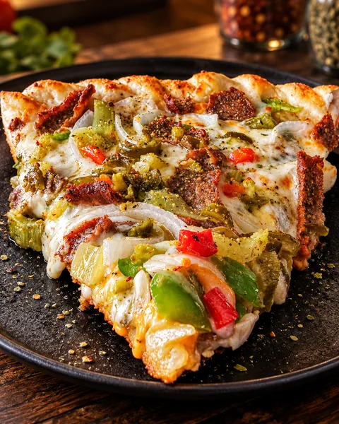 Slice of Frato’s Chicago-Style Gyro Pizza with gyro meat, peppers and giardiniera