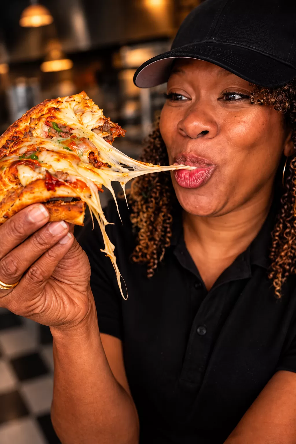 A bite of Frato’s stuffed crust pizza with a long cheese pull
